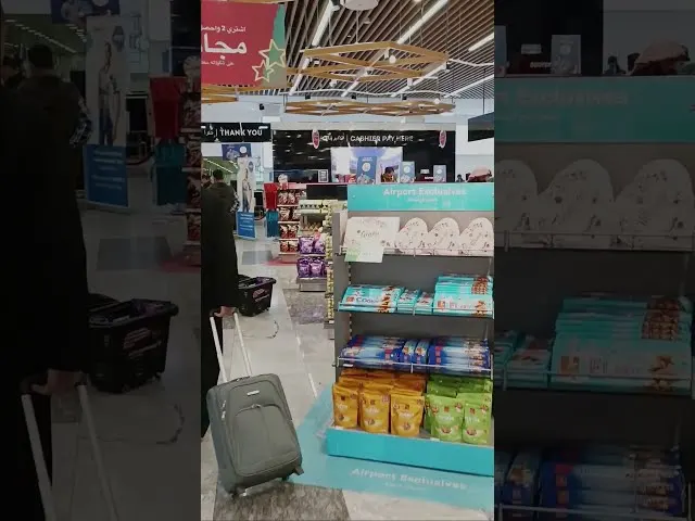 Airport duty-free shop display with turquoise shelving and packaged products