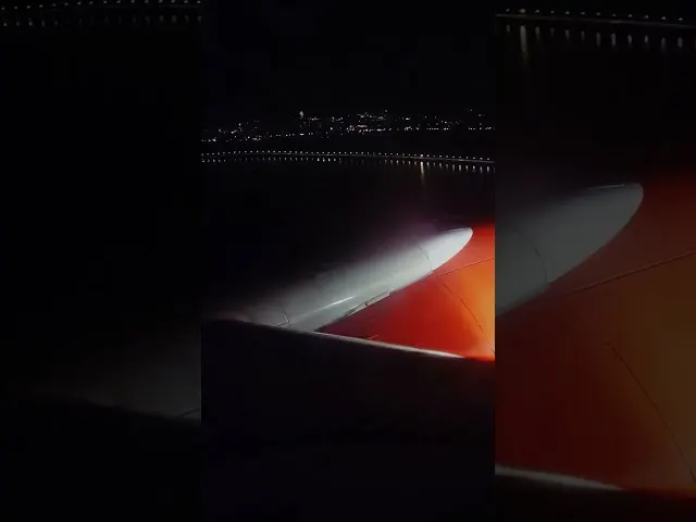 Aircraft wing illuminated by sunset light during evening flight