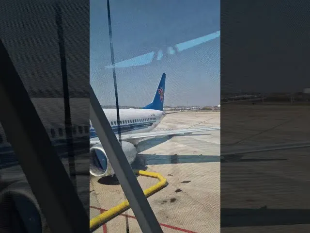China Southern Airlines aircraft parked at airport gate with ground equipment