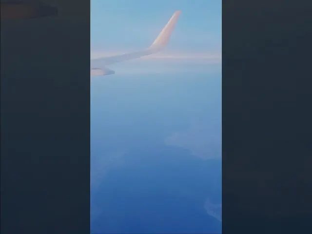 Aircraft wing view above clouds during daytime flight