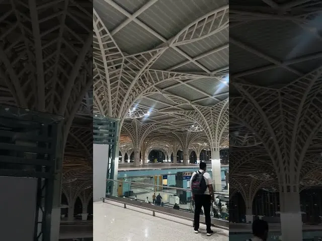 Modern airport terminal with ornate white structural columns and indoor pool