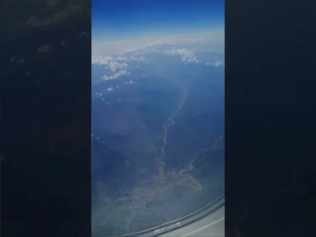 Aerial view of winding river through landscape from airplane window