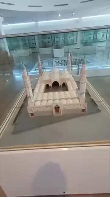 Detailed white miniature mosque model with domes and minarets inside the Islamic Arts Museum Kuala Lumpur